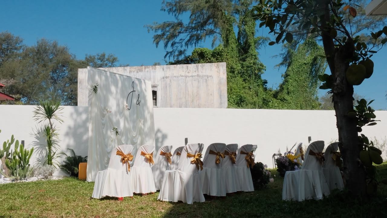Garden ceremony set up on the lawn with white chairs and a floral arch